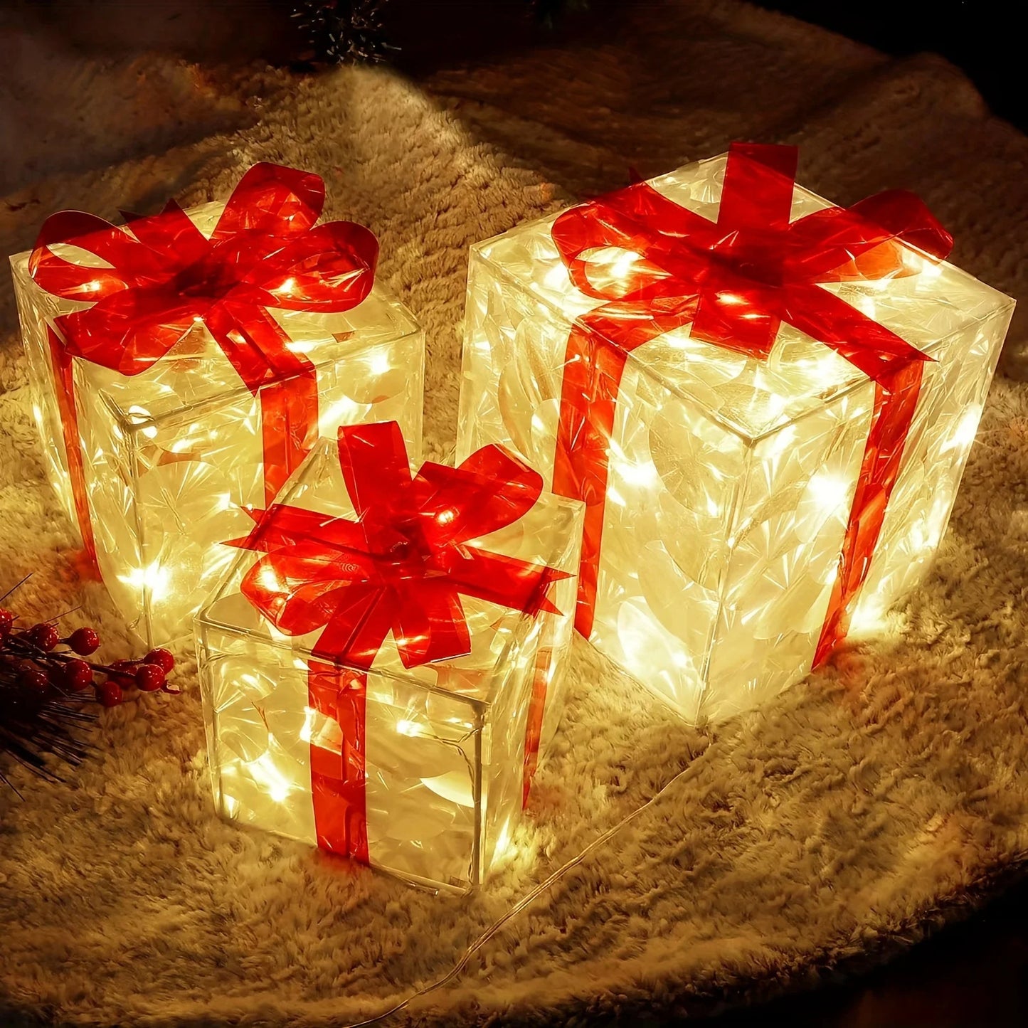 Decorative light-up gift boxes with red ribbons on a soft surface