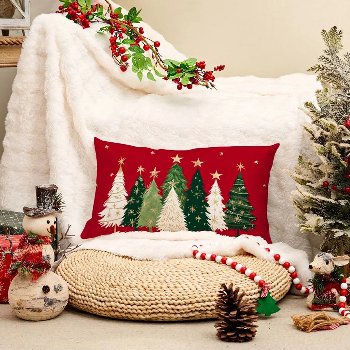 Decorative Christmas pillow with tree design on a cozy setting with a blanket and small tree.