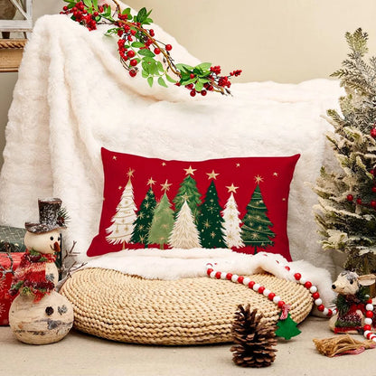 Decorative Christmas pillow with tree design on a cozy setting with a blanket and small tree.