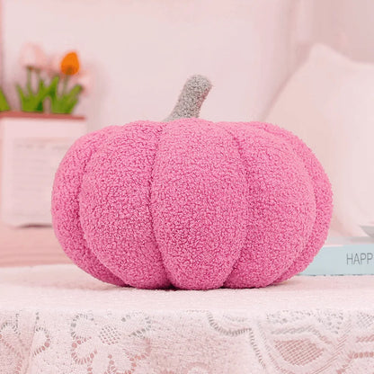 Pink pumpkin-shaped pillow on a lace surface with a blurred background