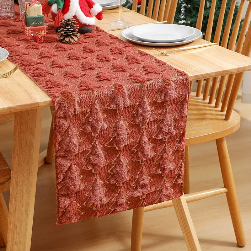 Dining table with a textured red table runner, plates, and glasses on a wooden table.