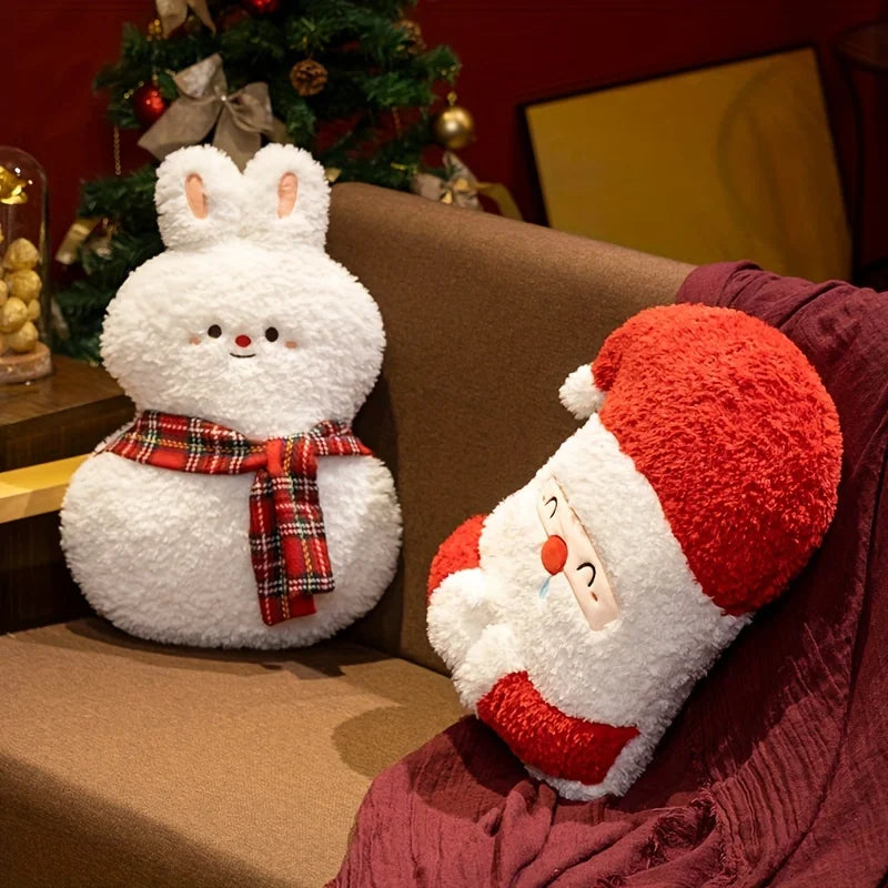 Plush toys resembling a snowman and Santa Claus on a couch with a Christmas tree in the background.