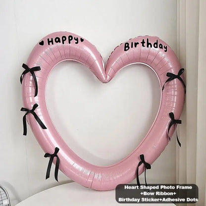 Heart-shaped pink photo frame with black bows and 'Happy Birthday' text on a white background.