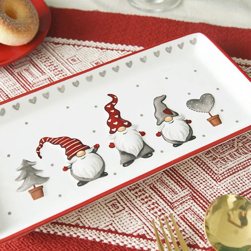 Decorative plate with Christmas-themed gnomes on a red and white patterned tablecloth.