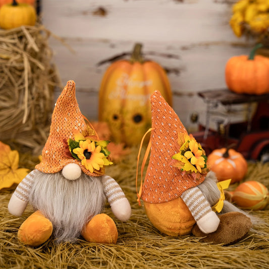 Two autumn-themed gnomes with pumpkins and hay in the background