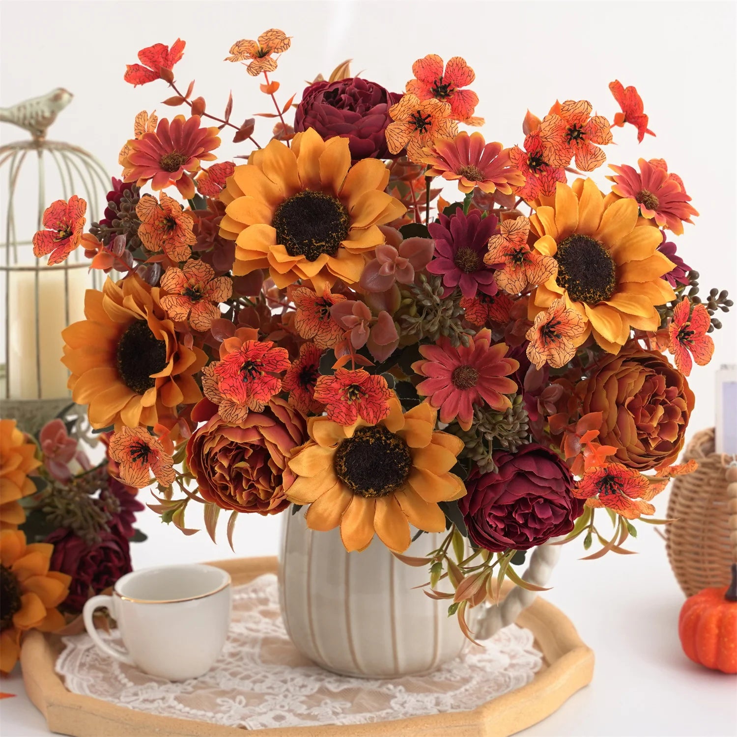 Autumn-themed floral arrangement with sunflowers and pumpkins on a decorative table.
