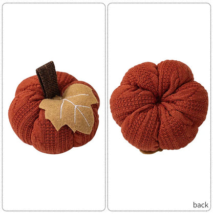 Two knitted pumpkins with a leaf on a white background