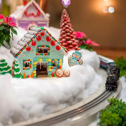 Gingerbread house with candy decorations on a miniature train set