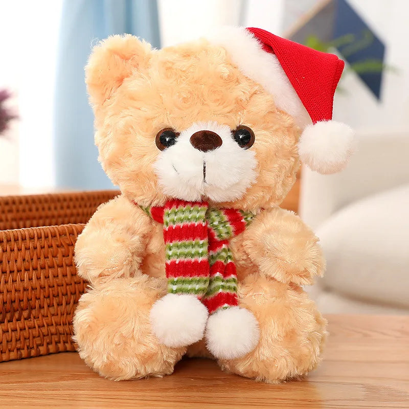 Plush teddy bear wearing a red Santa hat and scarf on a wooden surface.