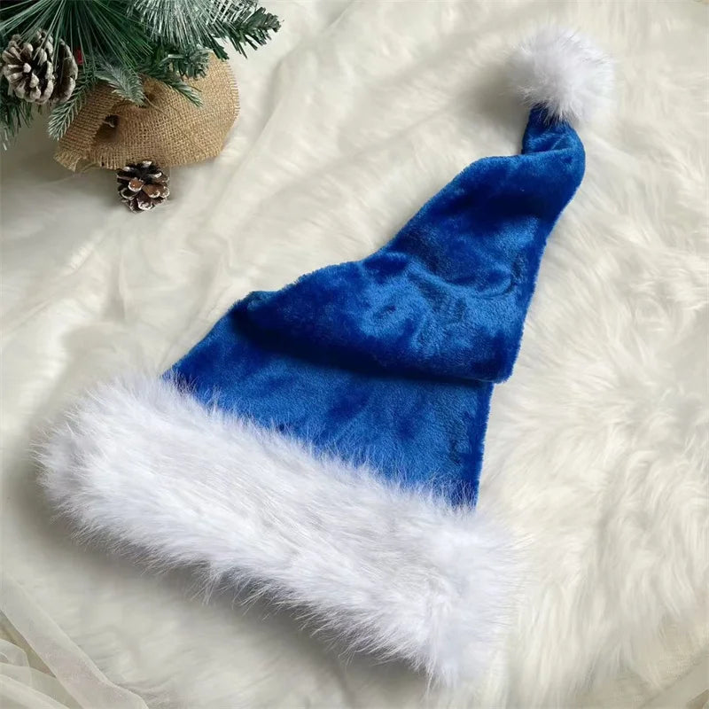 Blue Santa hat with white fur trim on a white fluffy surface with Christmas decorations.