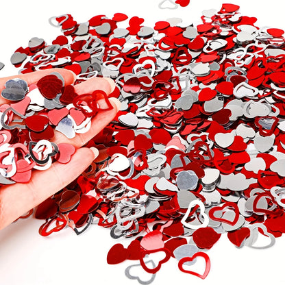 Red and silver heart-shaped confetti with a hand holding some confetti.