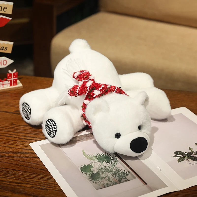 White teddy polar bear with a red bow on a wooden surface