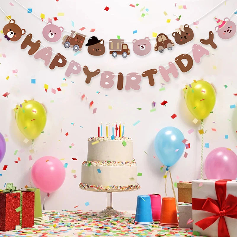 Birthday celebration with cake, balloons, and 'Happy Birthday' banner on a white wall.