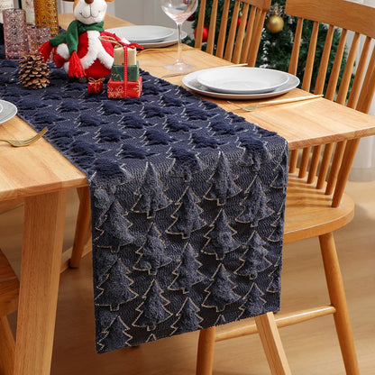 Navy blue textured table runner on a wooden dining table with Christmas decorations.