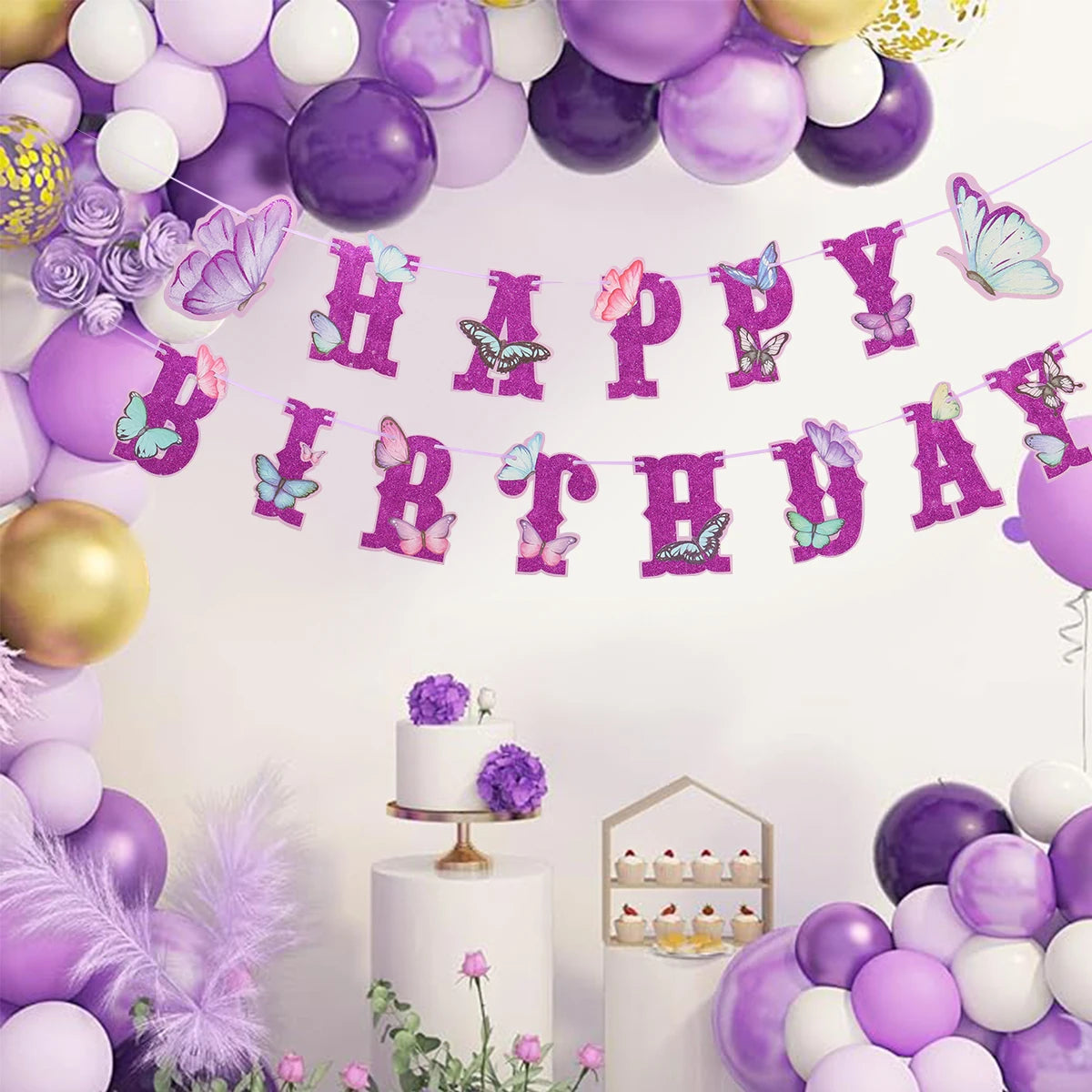 Birthday celebration setup with purple balloons, cake, and 'Happy Birthday' banner.