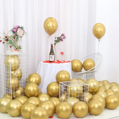 Gold balloons and a bottle of wine on a table with a white curtain background