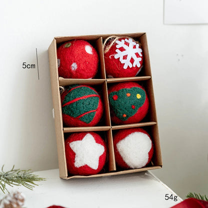 Box of red and green felt ornaments with snowflake and star designs on a white surface.
