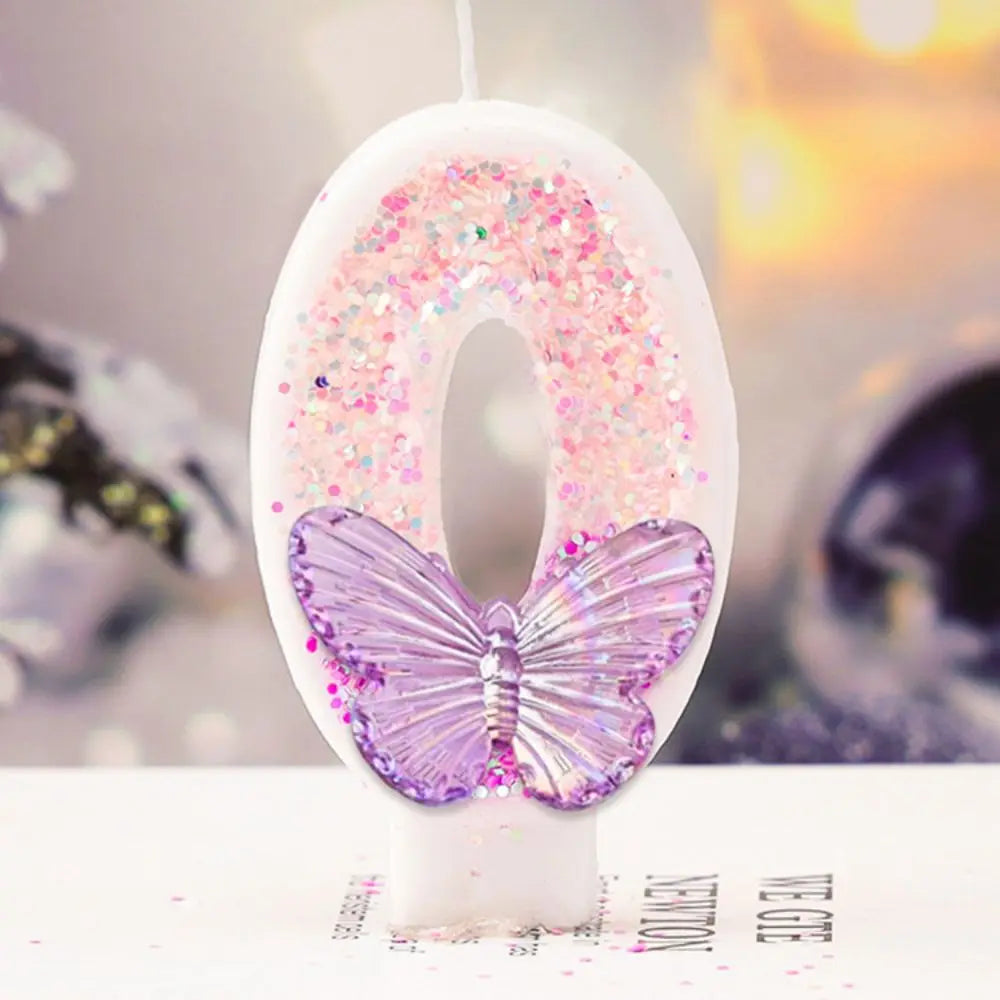 Decorative letter 'Q' with a butterfly and pink glitter on a blurred background