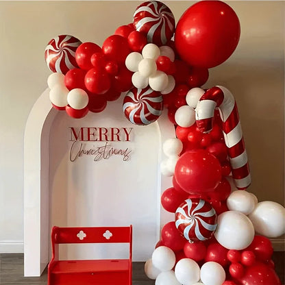 Decorative balloon arch with red, white, and candy cane theme in front of a 'Merry Christmas' sign.