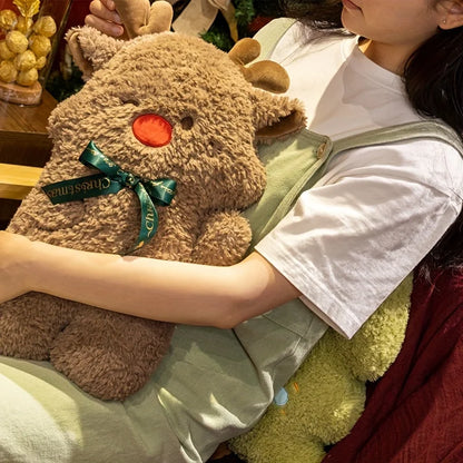 Person holding a plush toy with a green bow, sitting on a chair.