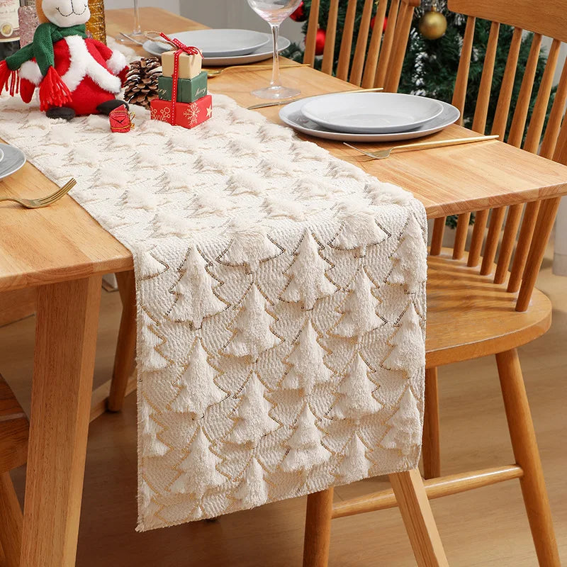 Dining table with a textured table runner, Christmas decorations, and wooden chairs.