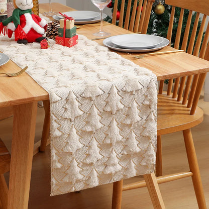 Dining table with a textured table runner, Christmas decorations, and wooden chairs.