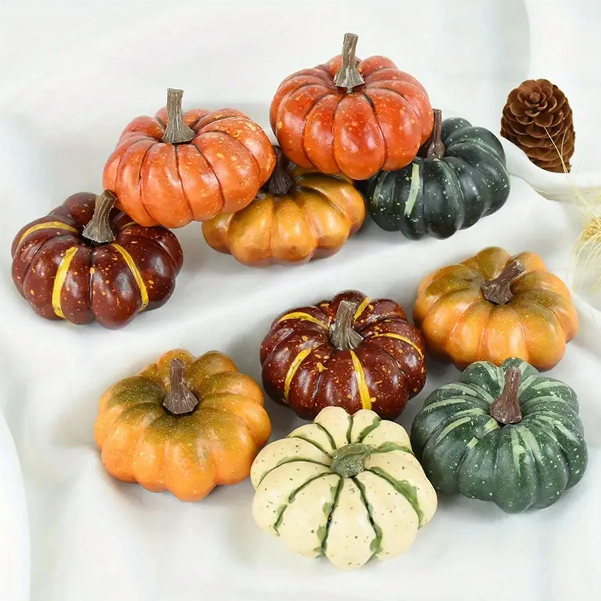 Assorted small pumpkins in various colors on a white surface