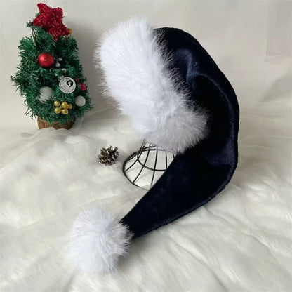 Black Santa hat with white fur on a white surface with a small Christmas tree in the background.