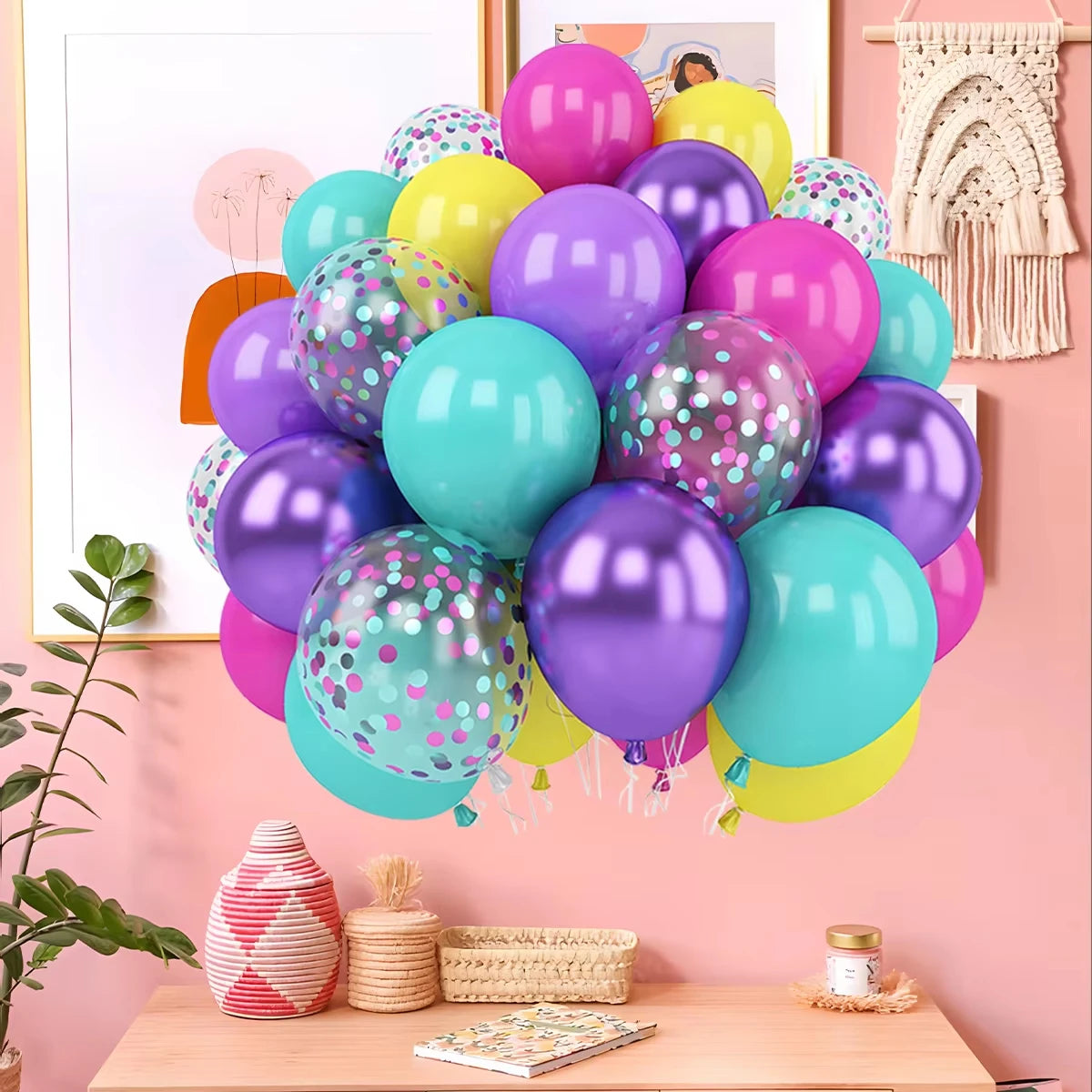 Colorful balloons with polka dots on a pink wall with decor elements.