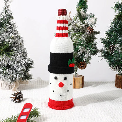 Knitted snowman bottle cover on a wine bottle with Christmas decorations in the background.