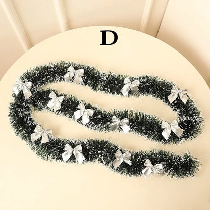 Decorative tinsel with silver bows on a beige surface
