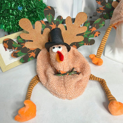 Decorative plush toy resembling a turkey with antlers and a pilgrim hat on a white surface.