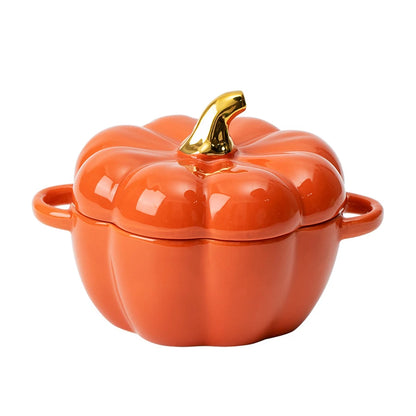 Orange pumpkin-shaped cookware with a gold lid knob on a white background