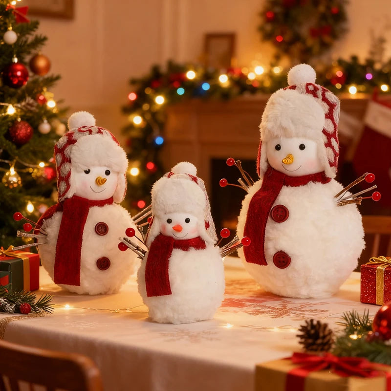 Three snowman decorations on a table with a Christmas tree and wreath in the background.