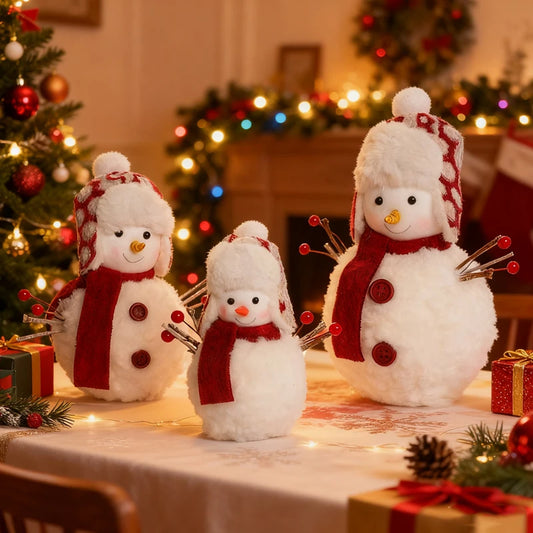 Three snowman decorations on a table with a Christmas tree and wreath in the background.