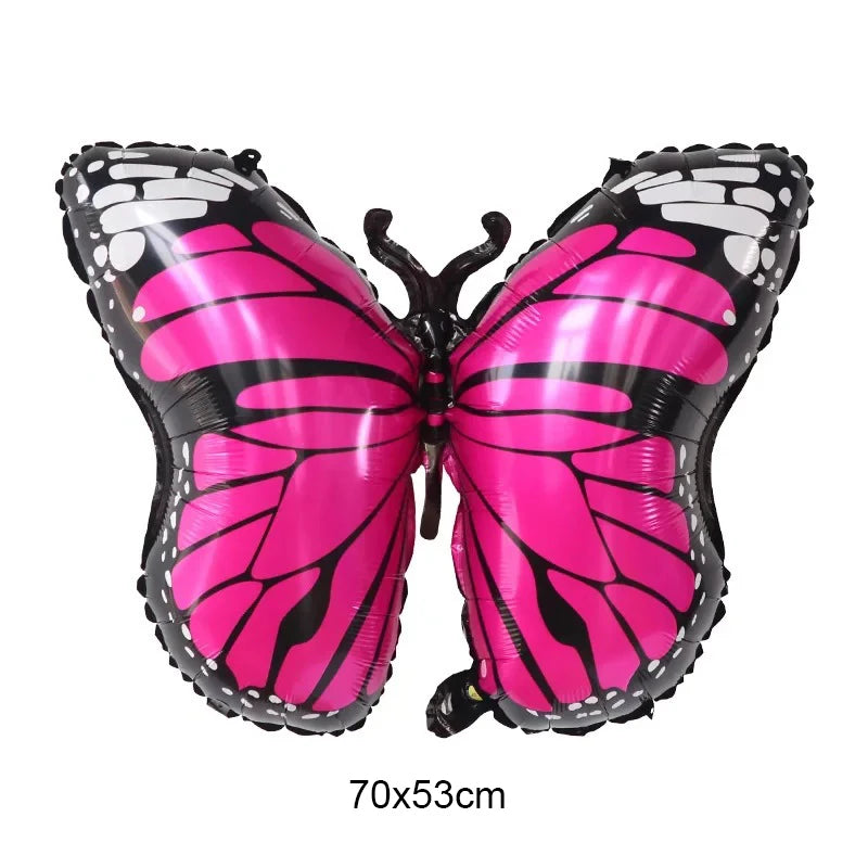Butterfly-shaped balloon with pink and black wings on a white background