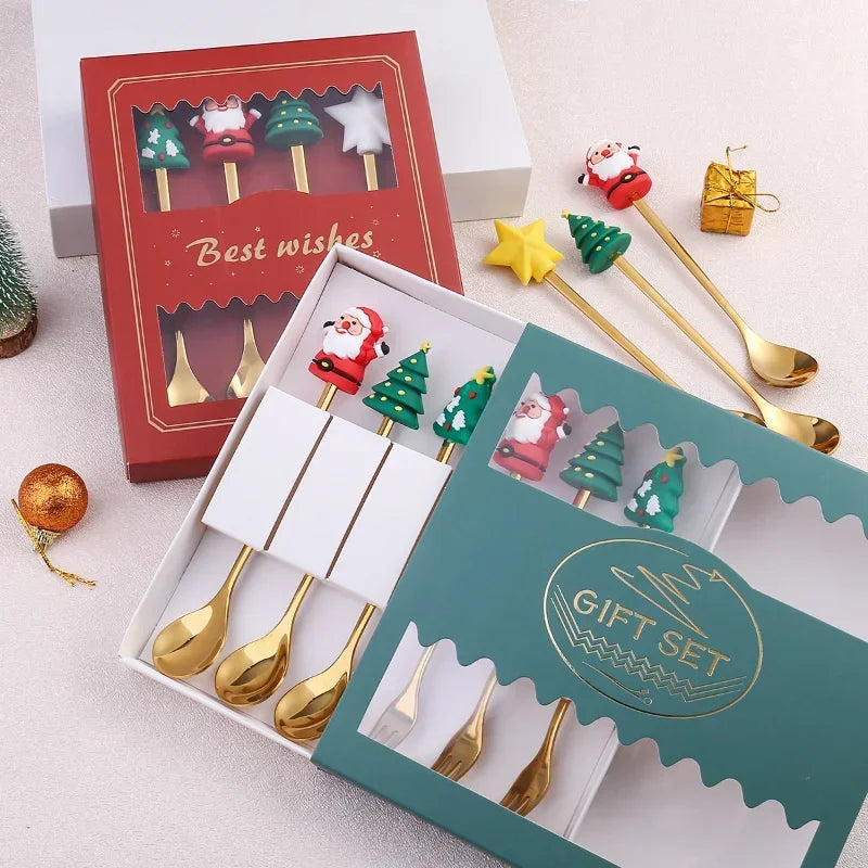 Set of gold Christmas-themed spoons in decorative boxes on a light surface.