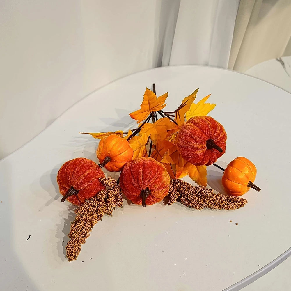 Decorative arrangement of pumpkins and leaves on a white surface