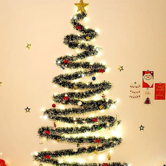 Decorated Christmas tree with lights and ornaments on a beige wall.