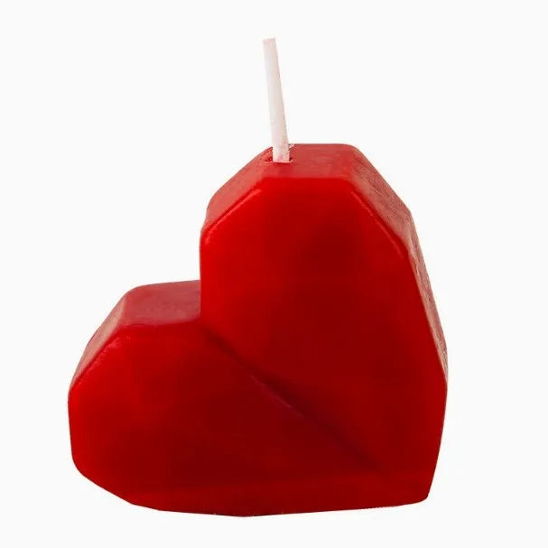 Red heart-shaped candle on a white background