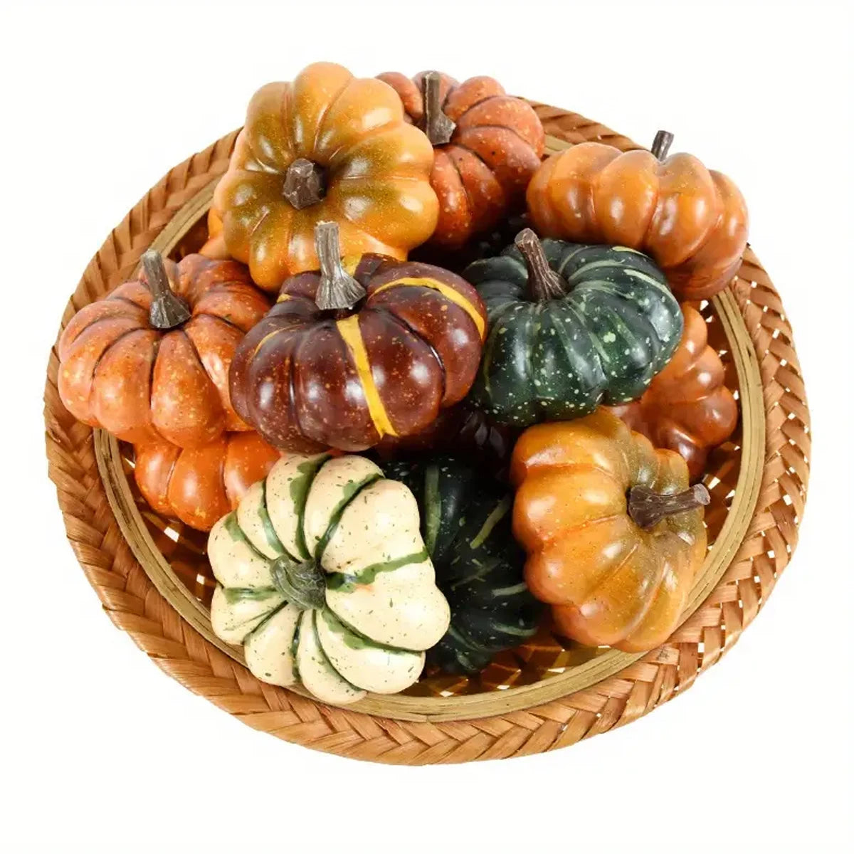 Assorted small pumpkins and gourds in a woven basket on a white background