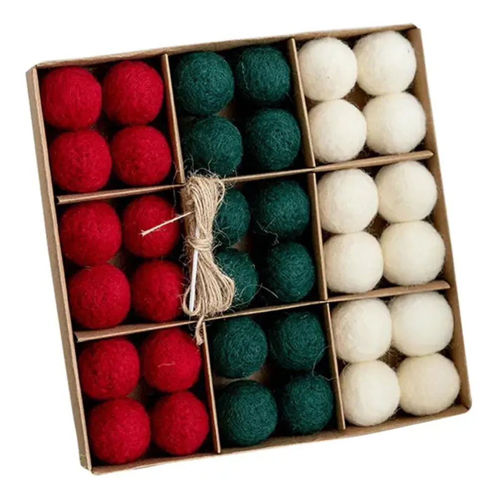 Box of red, green, and white felt balls tied with twine on a white background