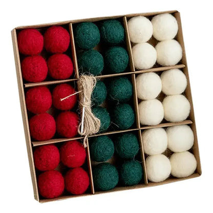 Box of red, green, and white felt balls tied with twine on a white background