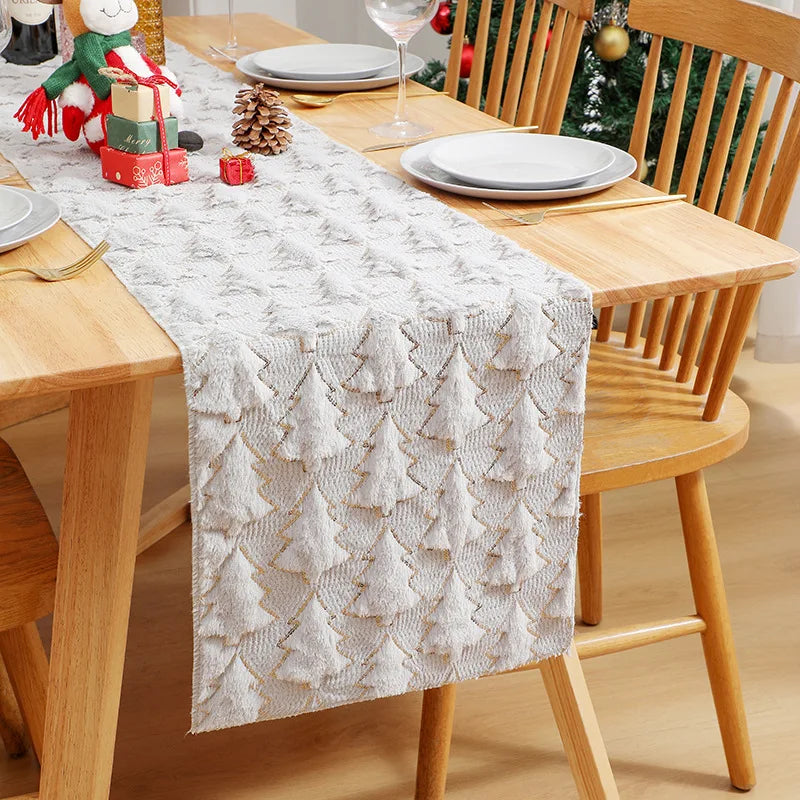 Dining table set with a decorative table runner featuring Christmas tree patterns, surrounded by wooden chairs.