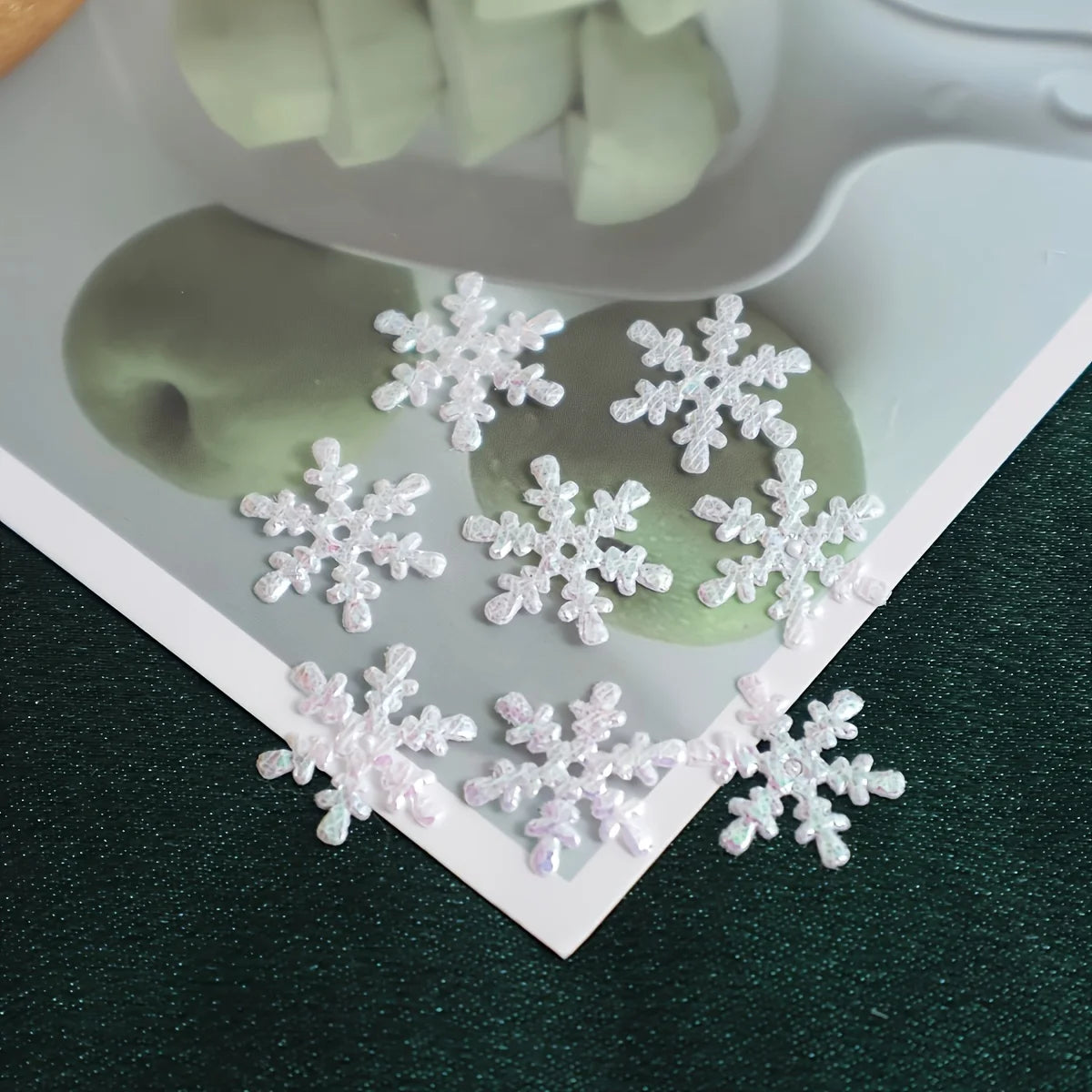 White snowflake-shaped decorative items on a green surface