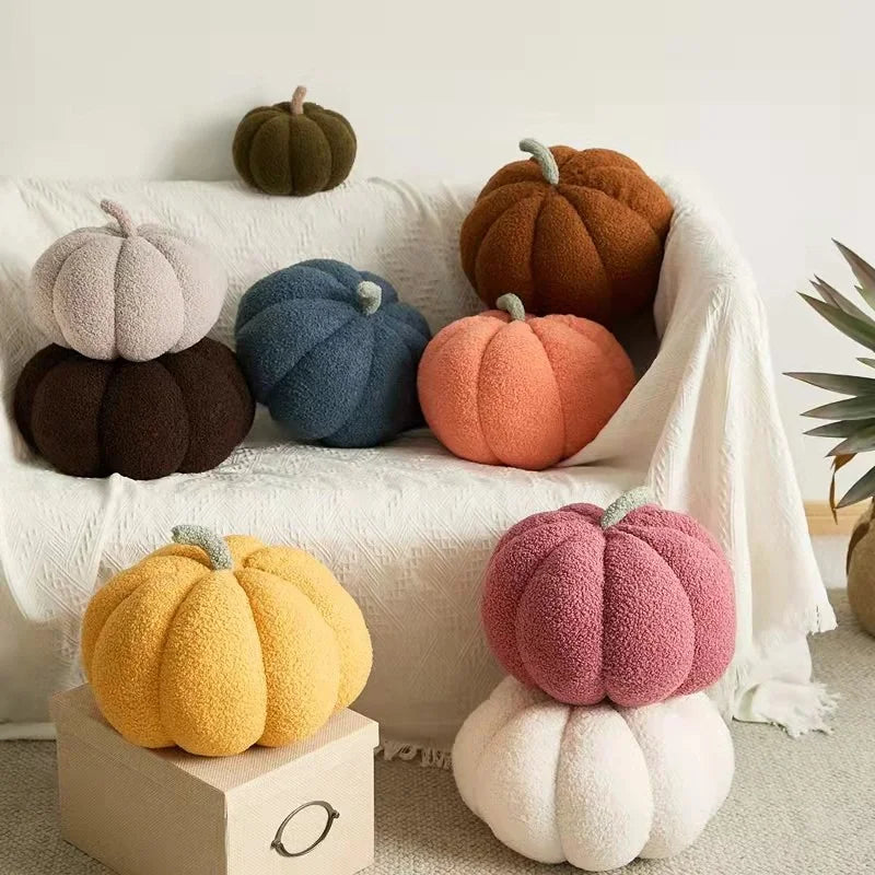 Colorful pumpkin-shaped cushions on a sofa and a small table.