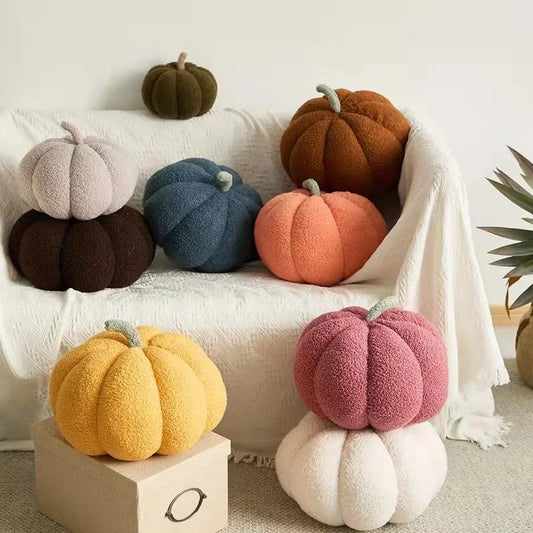 Colorful pumpkin-shaped cushions on a sofa and a small table.