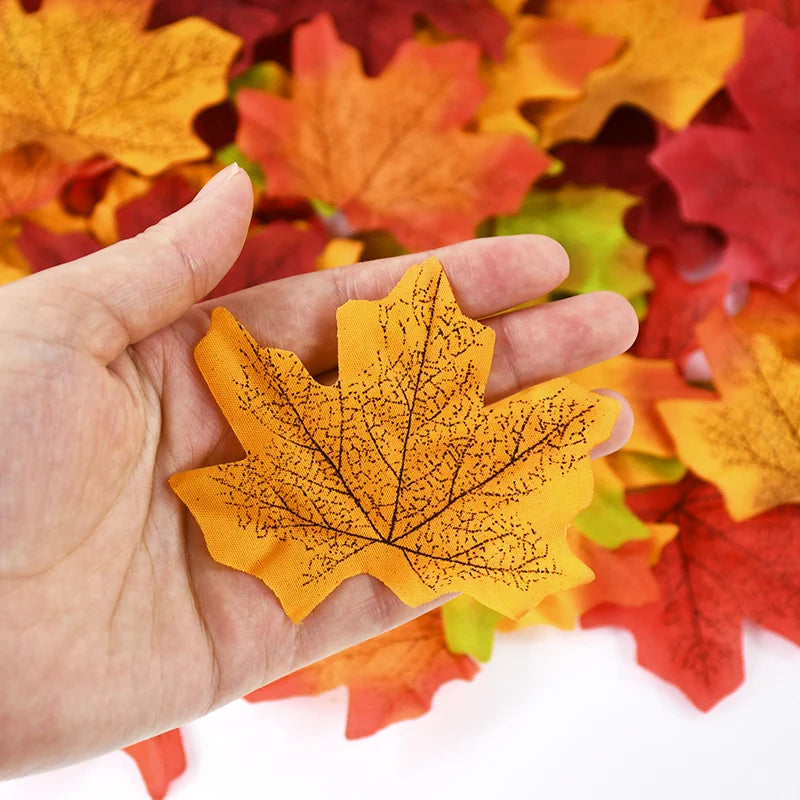Hand holding a yellow leaf-shaped object with more leaves in the background