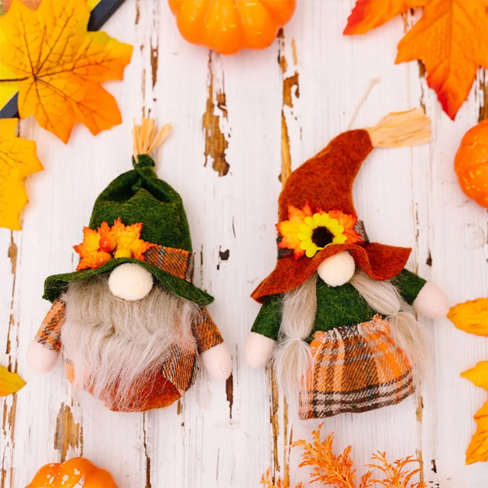 Two autumn-themed gnomes with plaid hats and scarves, surrounded by pumpkins and leaves on a wooden surface.