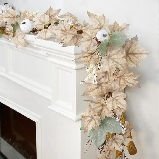 Decorative leaf garland with white pumpkins on a fireplace mantel.